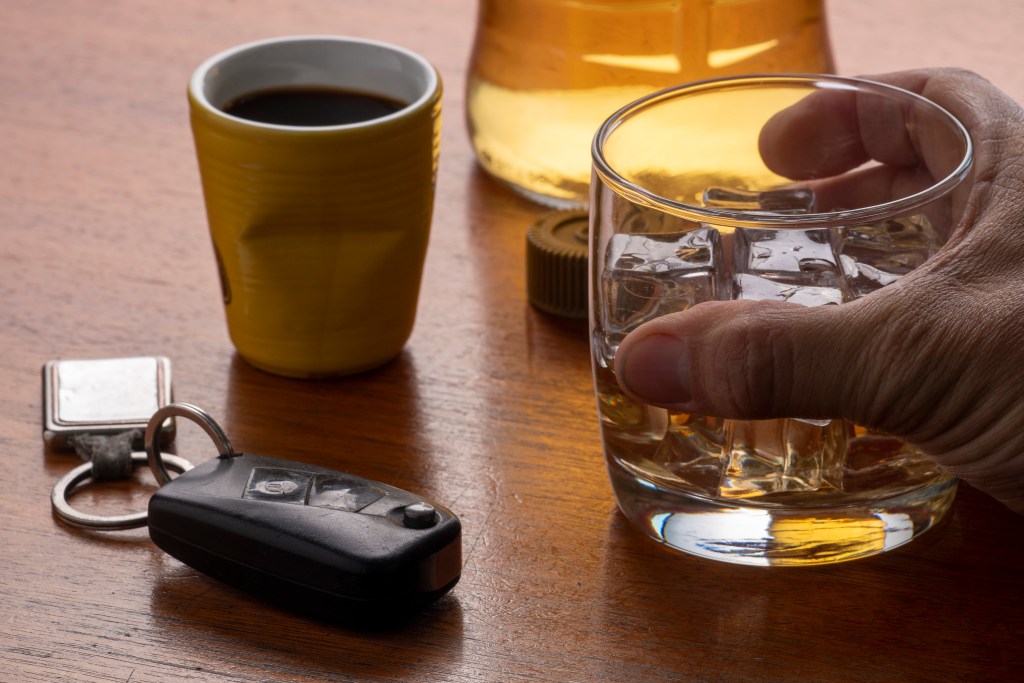 alcohol abuse with glass whiskey with ice car key table