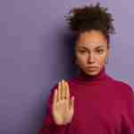 pretty serious woman pulls palm show no rejection gesture refuses says hold dressed casual poloneck being interested something tries calm someone stop here