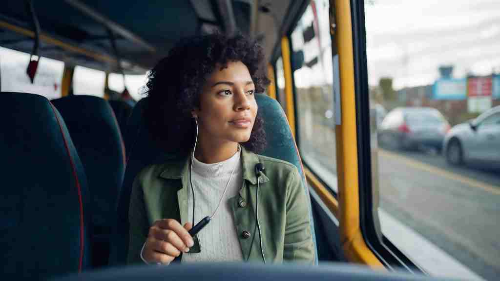 woman passenger seat bus listens music