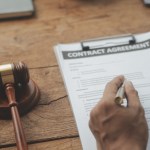 business lawyers discussing contract papers with brass scale desk office law legal services advice justice law concept picture with film grain effect