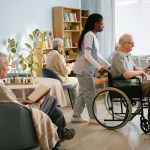 caring nurse assisting elderly man wheelchair