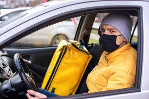 courier car with black medical mask delivery backpack seat food delivery service