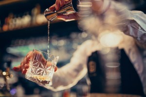 handsome bartender making drinking cocktails counter