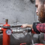 man looks faucet pipes valve pressure meter