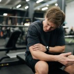 medium shot beginner sportsman having accident injury hurt arms while workout with barbell